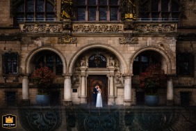 Romantic wedding portrait of a couple in front of the historic Duisburg Rathaus in Germany.